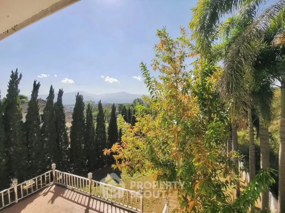 Stunning garden view from a spacious balcony with lush greenery and distant mountains.