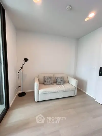 Cozy living room with modern sofa and stylish floor lamp, perfect for relaxation.