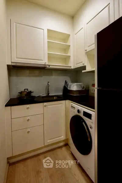 Compact kitchen with washing machine and sleek cabinetry