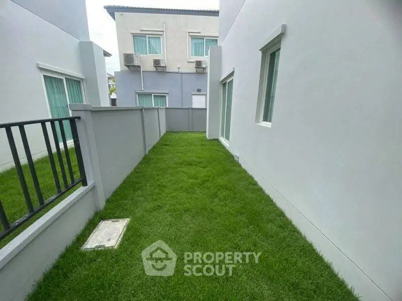 Charming townhouse with lush green backyard and modern exterior design.