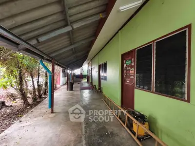 Charming rustic exterior with green walls and covered walkway, perfect for serene living.