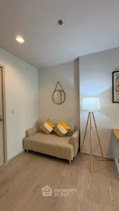 Cozy living room with modern decor, featuring a stylish sofa, floor lamp, and wall mirror for a welcoming ambiance.