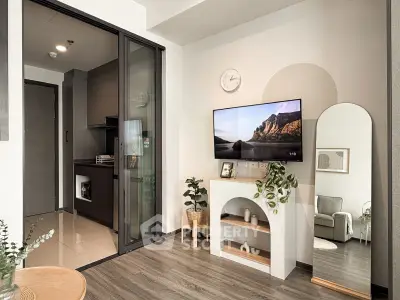 Modern living room with sleek TV setup and stylish decor, featuring a cozy corner and elegant flooring.