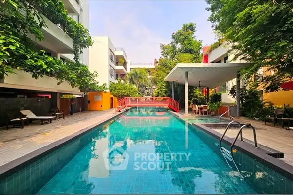 Luxurious residential pool area with lush greenery and modern design.