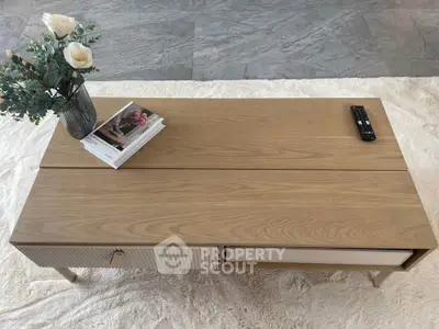 Stylish wooden coffee table with modern decor in a cozy living room setting.