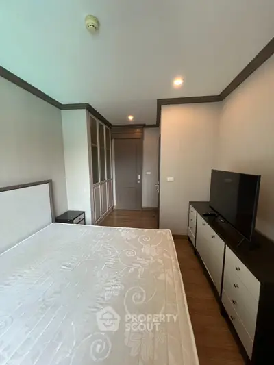 Spacious bedroom with modern furniture and ample storage in a stylish apartment.