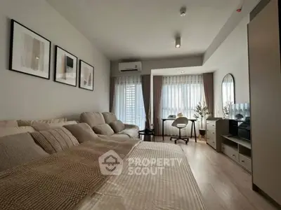 Modern bedroom with cozy seating area and large windows for natural light.