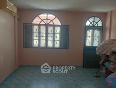 Spacious room with arched windows and tiled floor, perfect for customization.