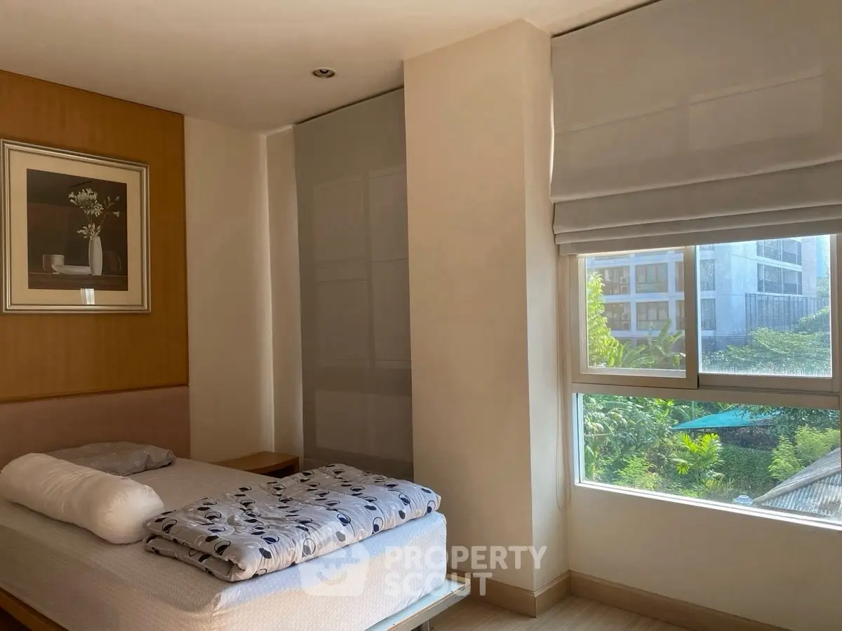 Bright bedroom with large window and modern decor in urban apartment