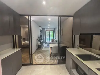 Modern open-layout kitchen leading to a stylish living area with natural light and sleek design.
