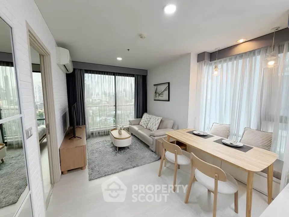 Modern living room with dining area, featuring large windows and stylish decor in a high-rise apartment.