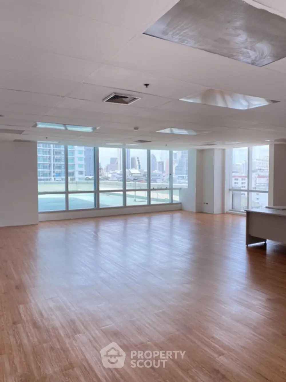Spacious open-plan living room with large windows and city view