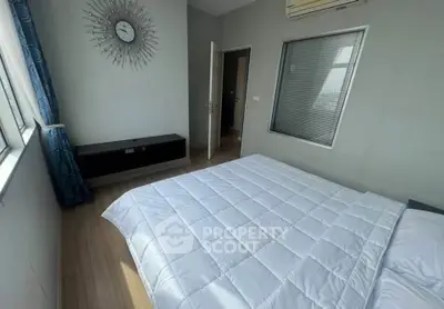 Spacious bedroom with modern decor and large window for natural light.