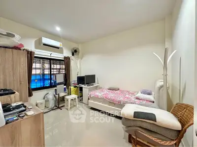 Cozy bedroom with modern amenities and natural light, perfect for relaxation and comfort.
