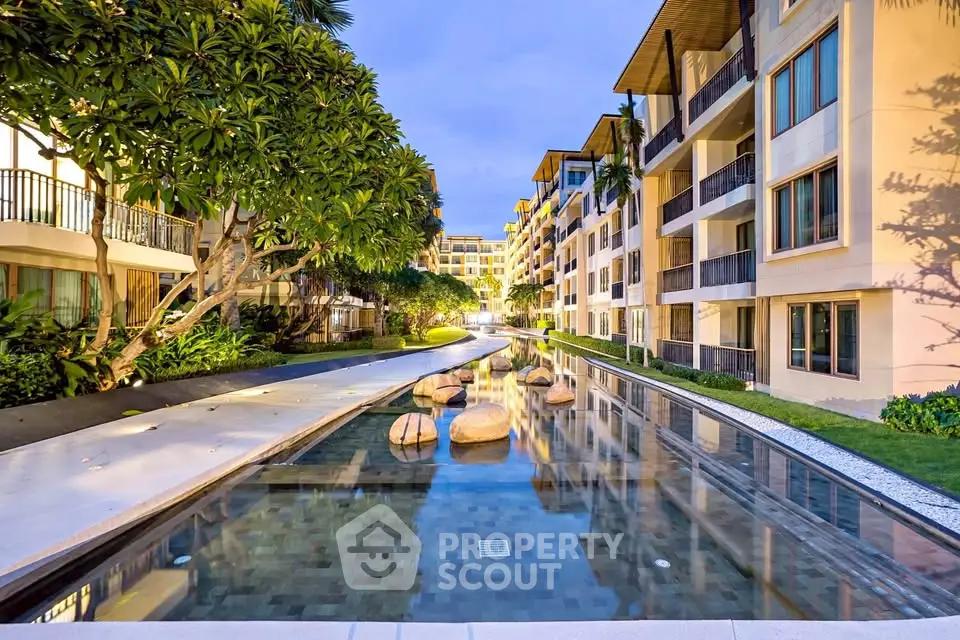 Luxurious apartment complex with serene water feature and lush landscaping.