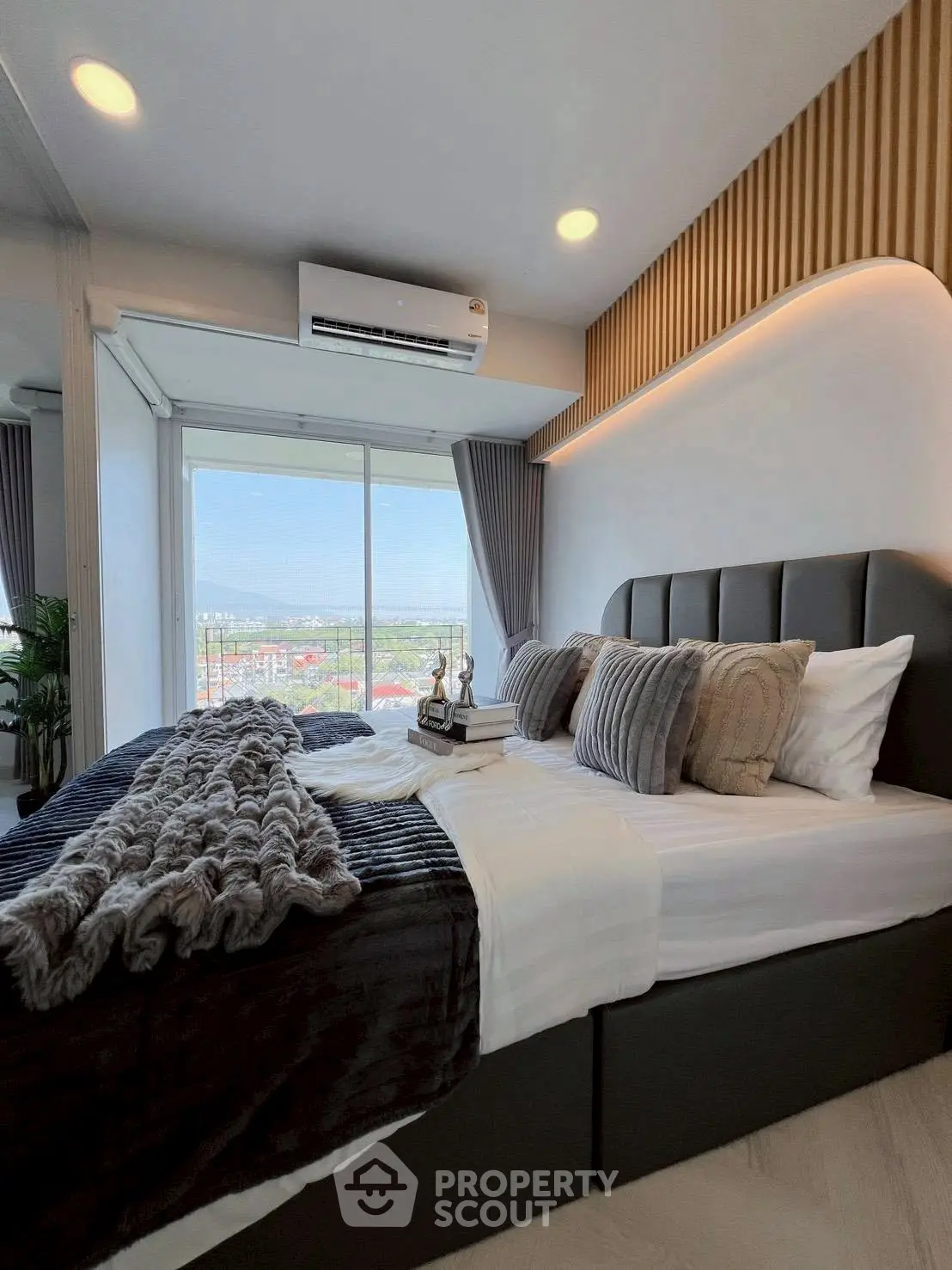 Luxurious bedroom with stunning view and modern decor, featuring plush bedding and elegant lighting.