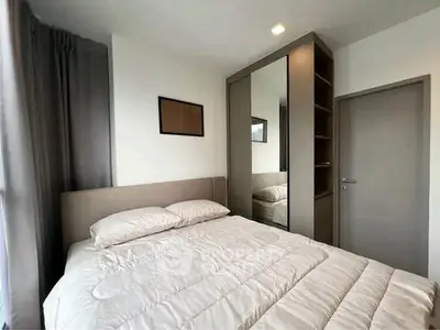 Cozy bedroom with modern decor and ample natural light, featuring a comfortable bed and sleek wardrobe.