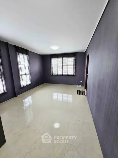 Spacious empty room with large windows and glossy tiled floor, perfect for customization.