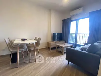 Modern living room with dining area and balcony view in a stylish apartment.