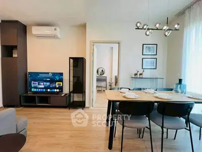 Modern living room with dining area, stylish furniture, and contemporary lighting in a cozy apartment.
