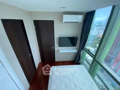 Modern bedroom with city view, featuring large windows, air conditioning, and sleek design.