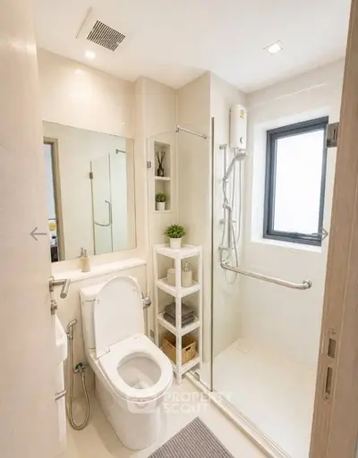 Modern bathroom with sleek shower and toilet, featuring minimalist design and natural light.