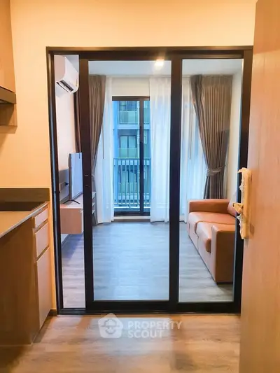 Modern living room with glass sliding doors and cozy sofa in a stylish apartment.