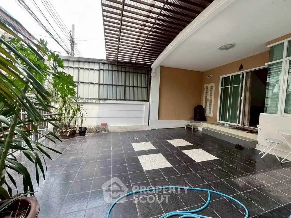 Spacious outdoor patio with tiled flooring and partial roof cover, perfect for relaxation and gatherings.