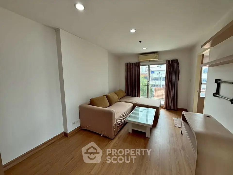 Spacious living room with modern sofa and large window offering natural light.