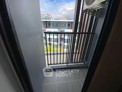Charming balcony with modern railing and scenic view of residential buildings.
