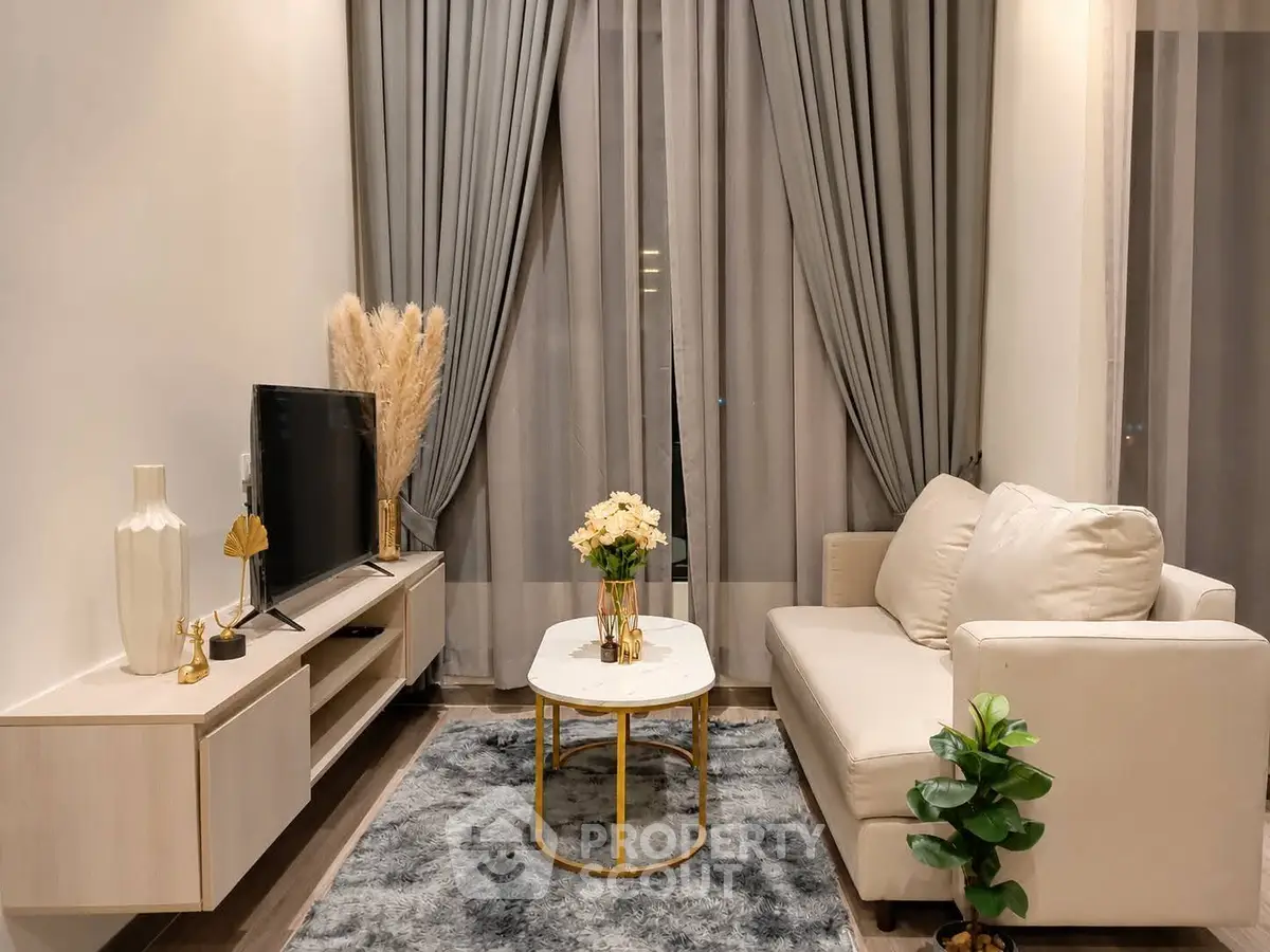 Elegant living room with modern decor, featuring a cozy sofa, stylish coffee table, and sleek entertainment unit.