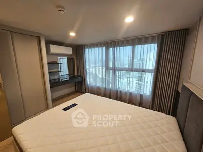 Modern bedroom with large window and city view, featuring built-in storage and air conditioning.