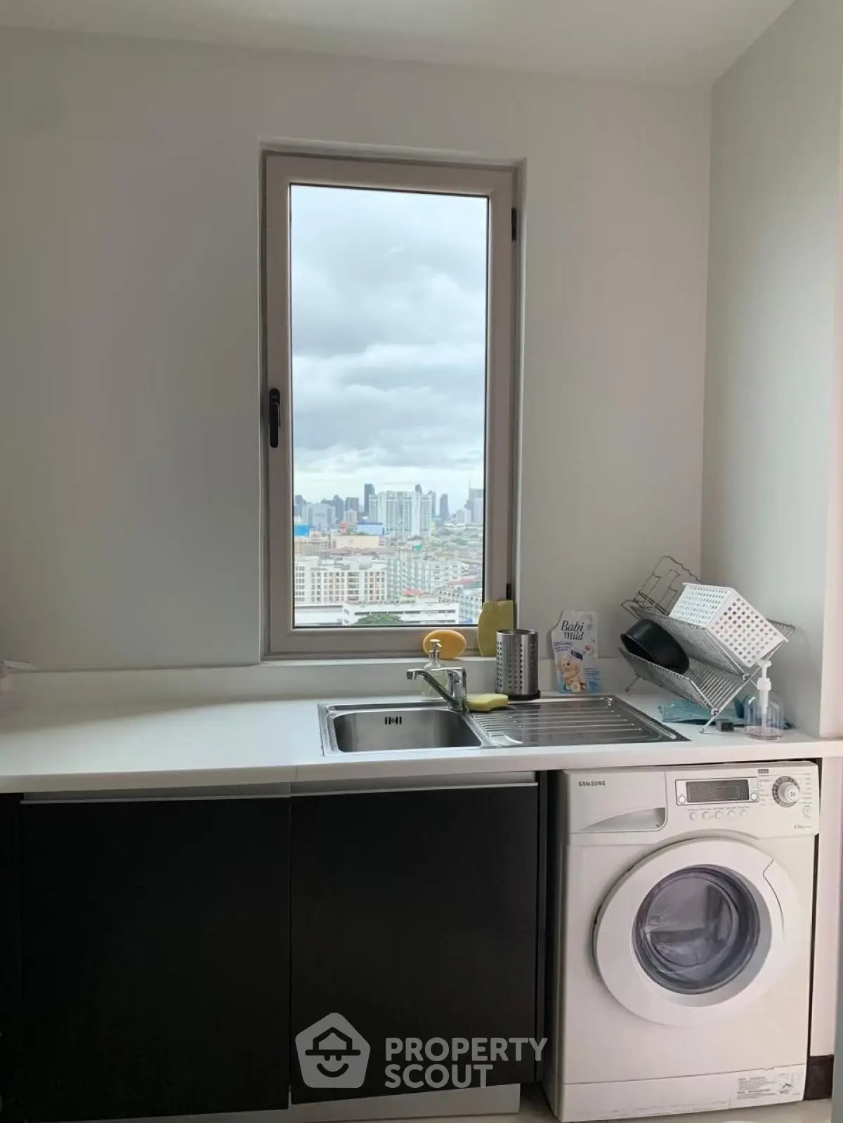 Modern kitchen with city view and washing machine, sleek design