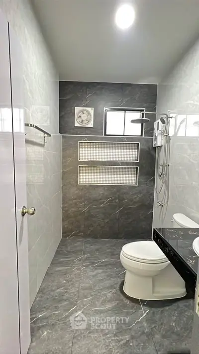 Modern bathroom with sleek gray tiles and contemporary fixtures.