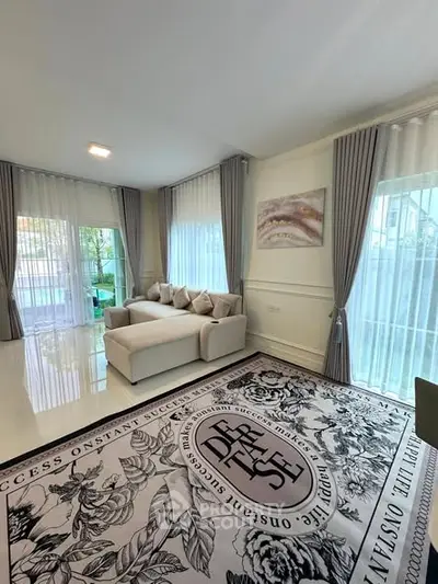 Elegant living room with large windows and stylish decor, featuring a cozy sofa and chic curtains.