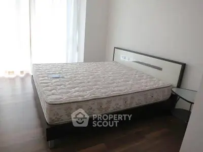 Spacious bedroom with large window and modern bed frame, perfect for natural light lovers.