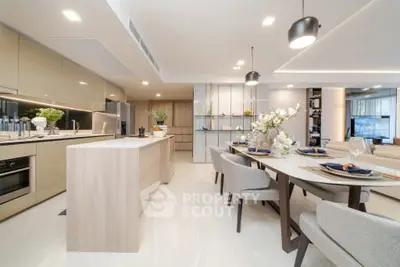 Luxurious open-plan kitchen and dining area with modern decor and ample natural light.