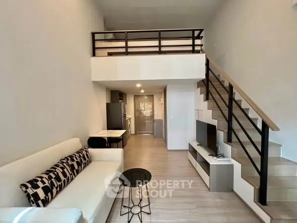 Modern loft-style living room with mezzanine, sleek staircase, and open layout for spacious living.