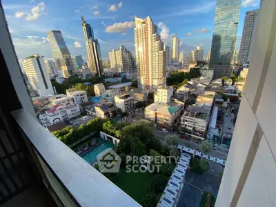 Stunning cityscape view from high-rise balcony overlooking urban skyline and lush greenery.