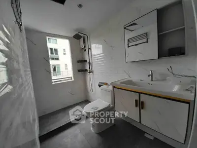 Modern bathroom with sleek fixtures and large window for natural light.