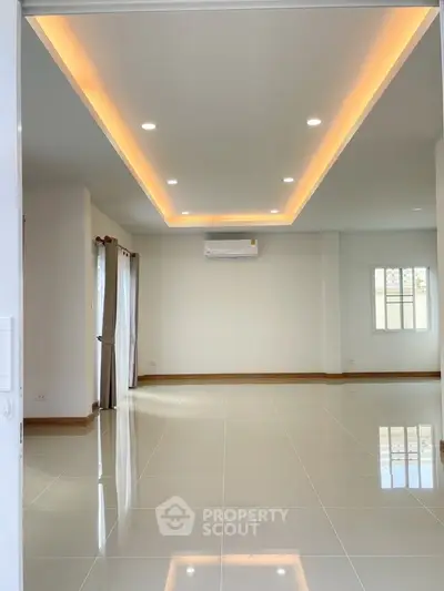 Spacious modern living room with recessed lighting and glossy tile flooring