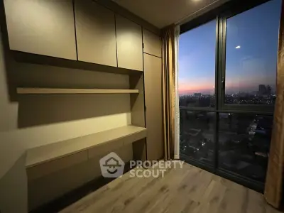 Modern bedroom with built-in storage and stunning city view at sunset