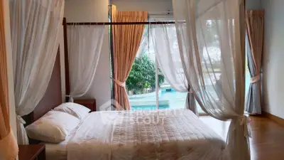 Luxurious bedroom with pool view and elegant drapery, perfect for serene living.