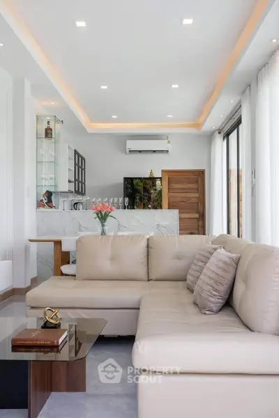 Luxurious modern living room with elegant decor and open kitchen layout, featuring a stylish sectional sofa and ambient lighting.