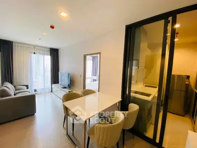 Modern open-plan living room with kitchen and dining area in a stylish apartment.