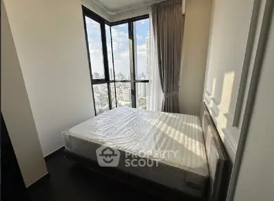Modern bedroom with large windows offering stunning city views, featuring a comfortable bed and elegant curtains.