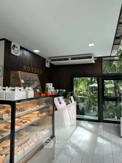 Charming cafe interior with modern design and lush garden view.