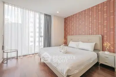 Elegant bedroom with modern decor and large window in a high-rise apartment.