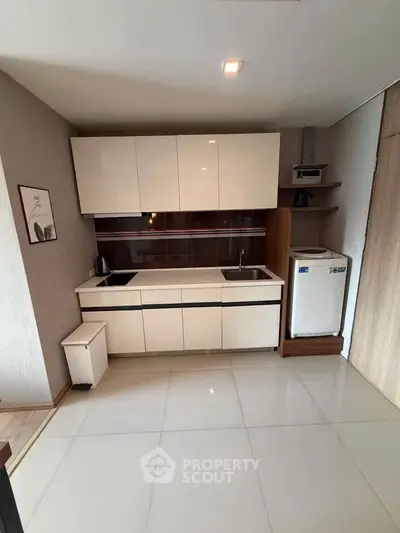 Modern kitchen with sleek cabinetry and integrated appliances in a compact layout.