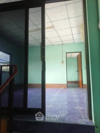 Spacious interior with blue patterned flooring and glass sliding doors, ideal for customization.